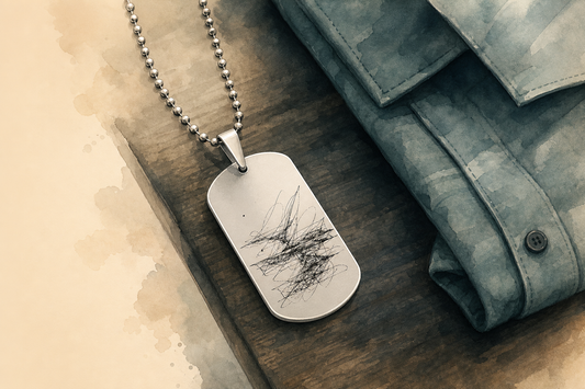 Colar masculino personalizado estilo dog tag em aço inox, com placa militar retangular gravada e corrente de bolinhas, ao lado de uma camisa dobrada