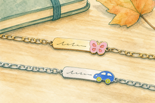 Ilustração em aquarela de duas pulseiras infantis personalizadas de aço inox, dourada com borboleta e prateada com carrinho, sobre mesa de madeira ao lado de um caderno